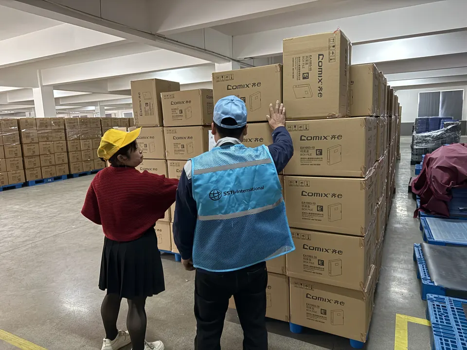 SSTI inspector checking export cartons stacked on pallets in a factory warehouse