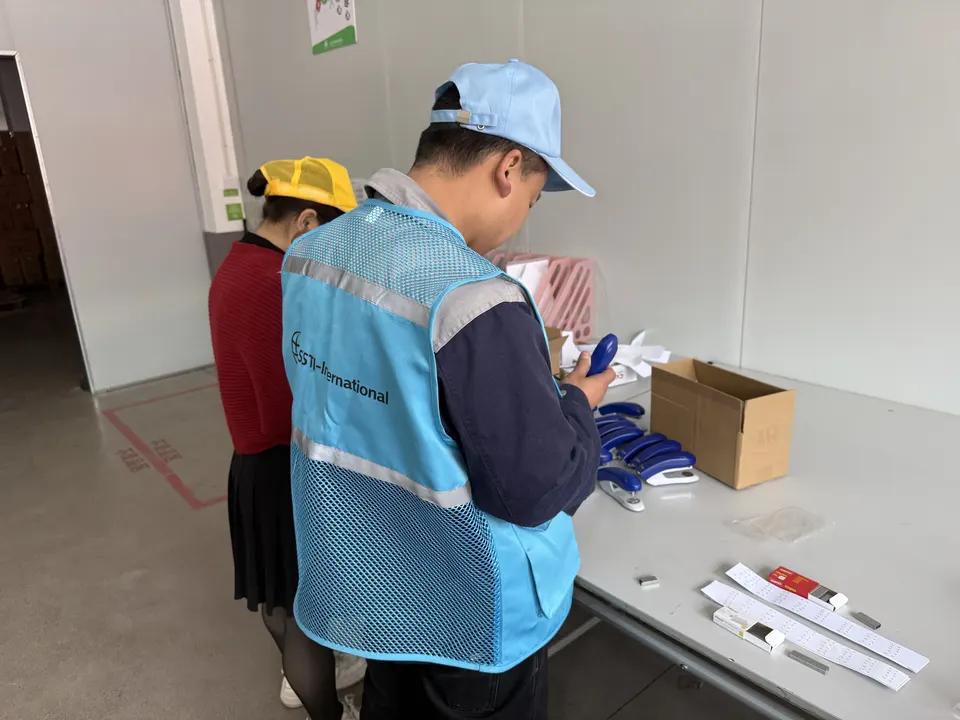 SSTI inspector examining sampled units at an inspection table with an opened carton