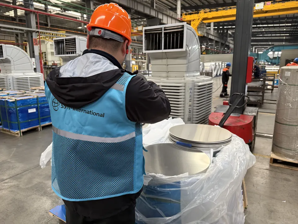 SSTI inspector checking stacked metal discs on a factory floor